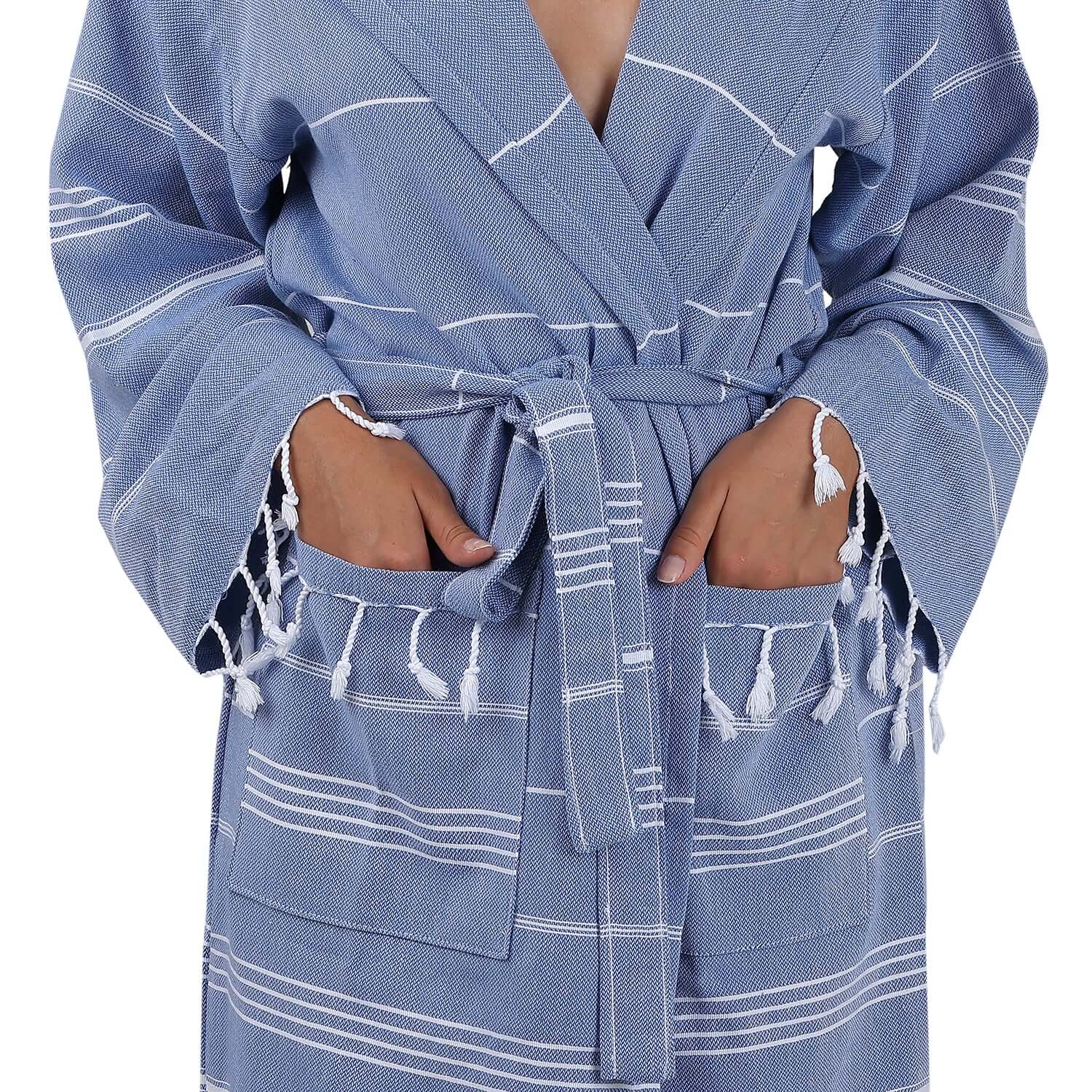 Close-up view of the Loom Legacy xsmall/small blue bathrobe, highlighting the intricate white stripe pattern, the tie belt, and the fringe detailing on the pockets